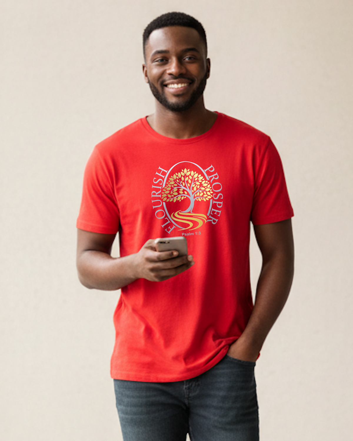 A smiling man wearing a bright red crewneck t-shirt with a circular graphic of a tree and the words 'FLOURISH PROSPER' in silver and gold, holding a smartphone against a plain beige background.