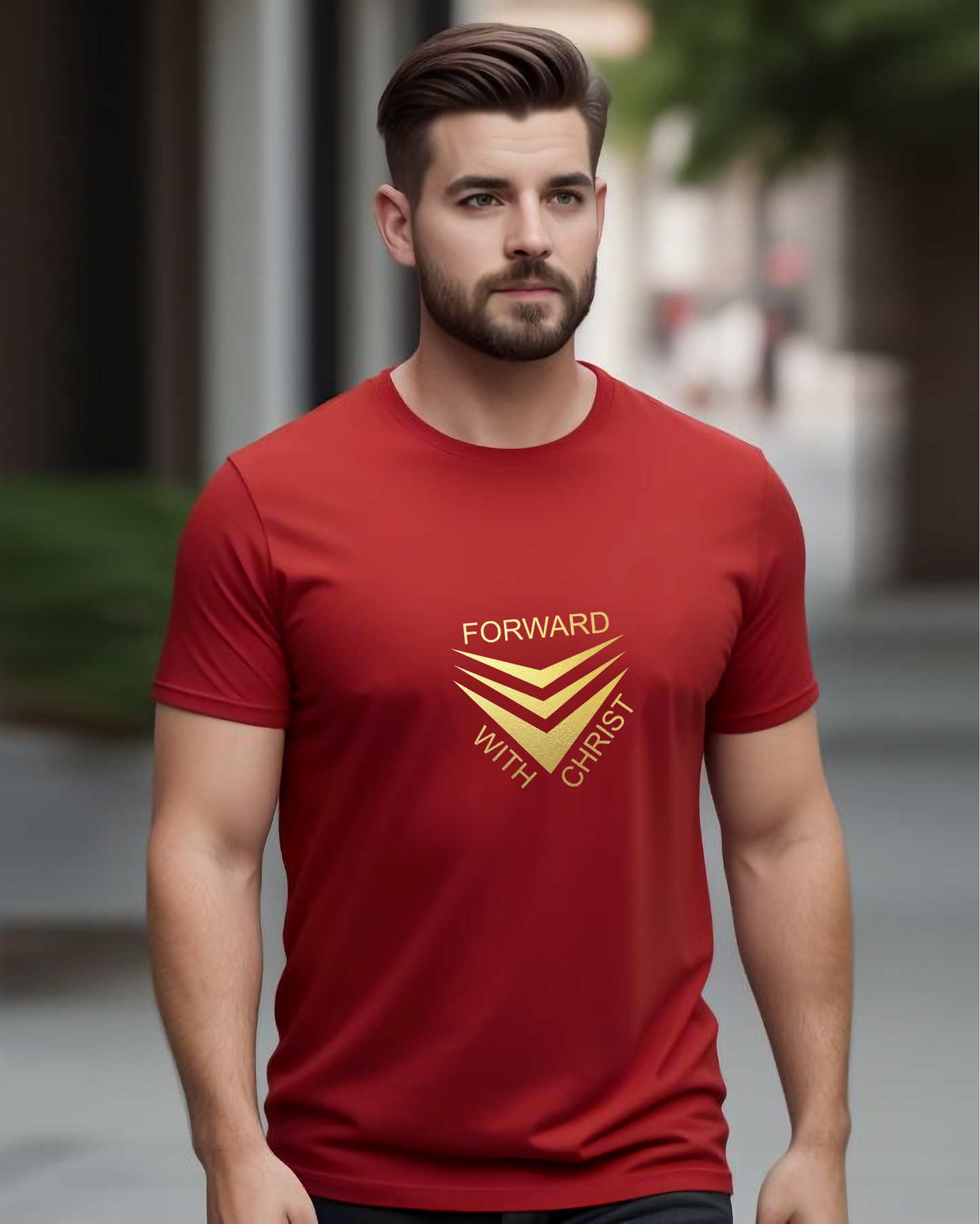 A man standing in a street wearing a red short sleeve t-shirt that has a gold logo with the words "FORWARD WITH CHRIST" around 3 downward pointing chevrons.