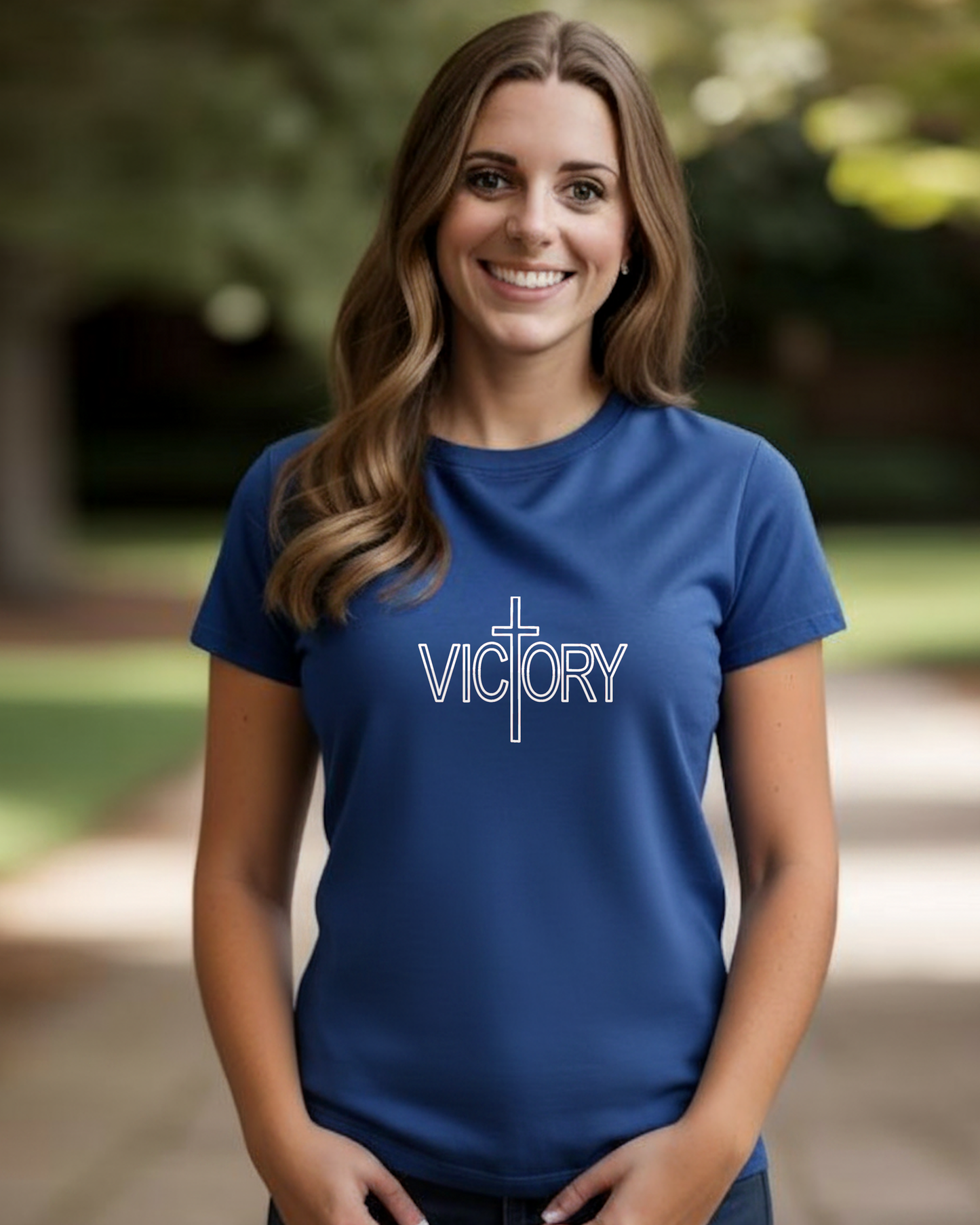 Woman wearing a royal blue t-shirt with a white 'Victory' logo in a park