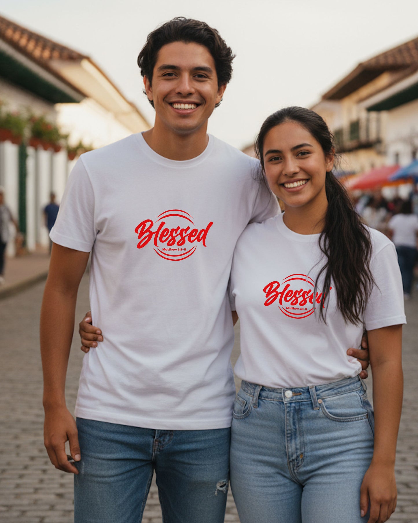 A south American man and woman wearing white t-shirts with 'Blessed' in red text, standing together outdoors.