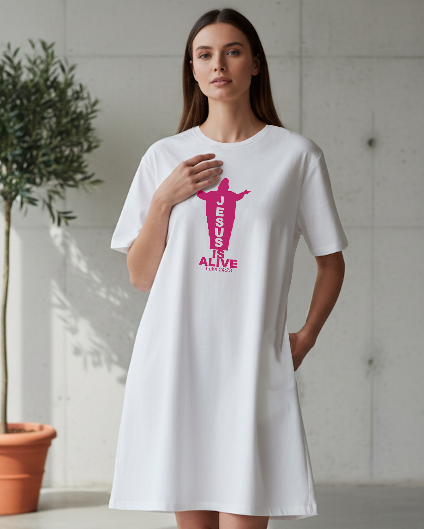 Woman wearing a white t-shirt with a red Jesus silhouette graphic and text, standing indoors.