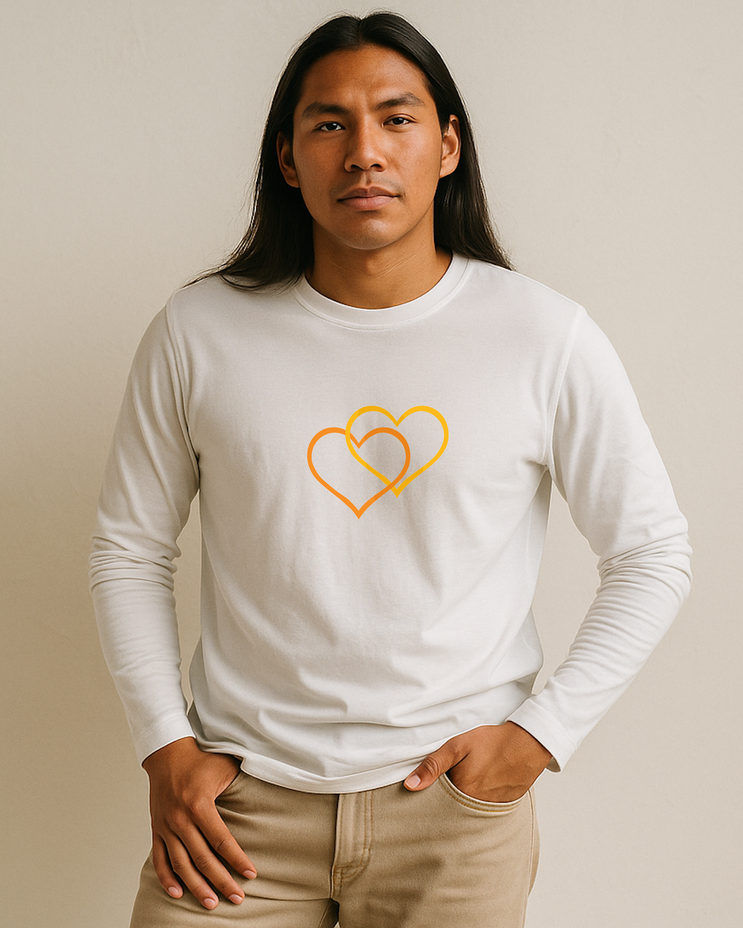 A man wearing a white long sleeve T-shirt with a dual inter-twinned heart design on a plain background