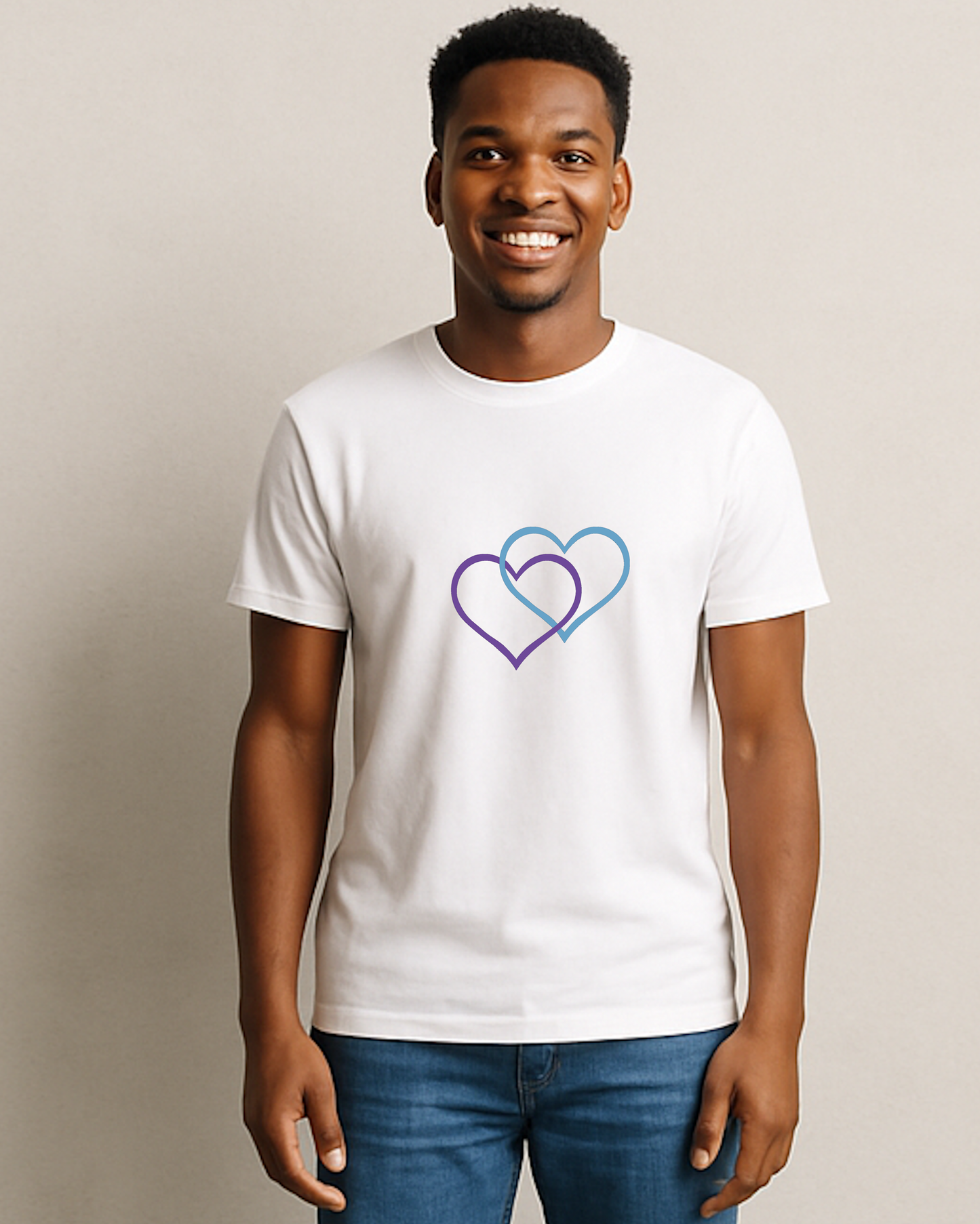 A man wearing a white t-shirt with a Heavenly Dreamwear logo comprised of a purple and blue inter-twinned hearts.