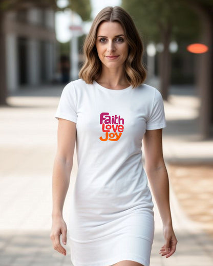 Woman wearing a white t-shirt dress with 'Faith Love Joy' text outdoors.