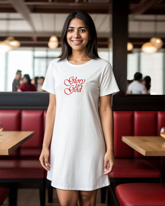 A woman in a restaurant wearing a green t-shirt dress with red text the says, 'Glory to God'