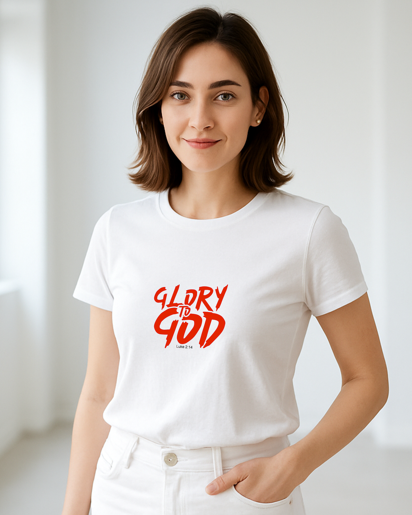 A woman indoors wearing a white t-shirt with a red Heavenly Dreamwear "Glory to God" logo printed on the front.