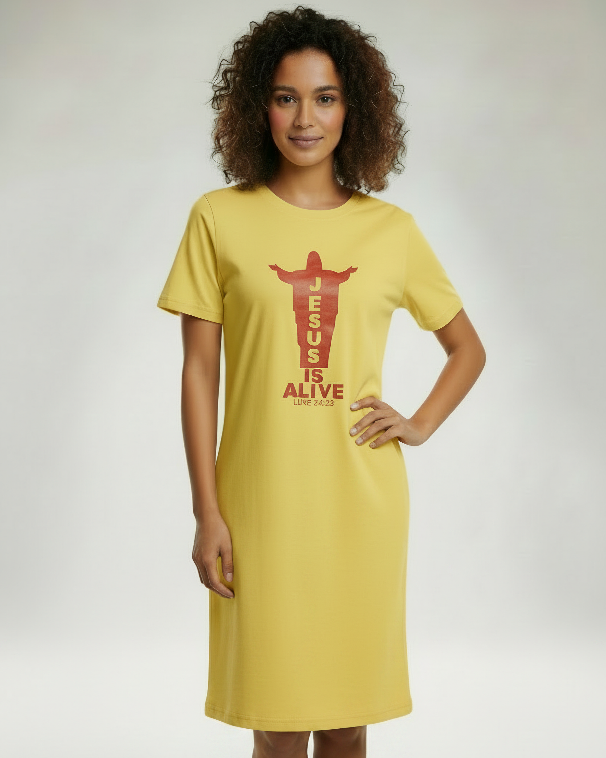 Woman wearing a yellow t-shirt dress with 'Jesus is Alive' text on a plain background