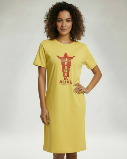 Woman wearing a yellow t-shirt dress with 'Jesus is Alive' text on a plain background
