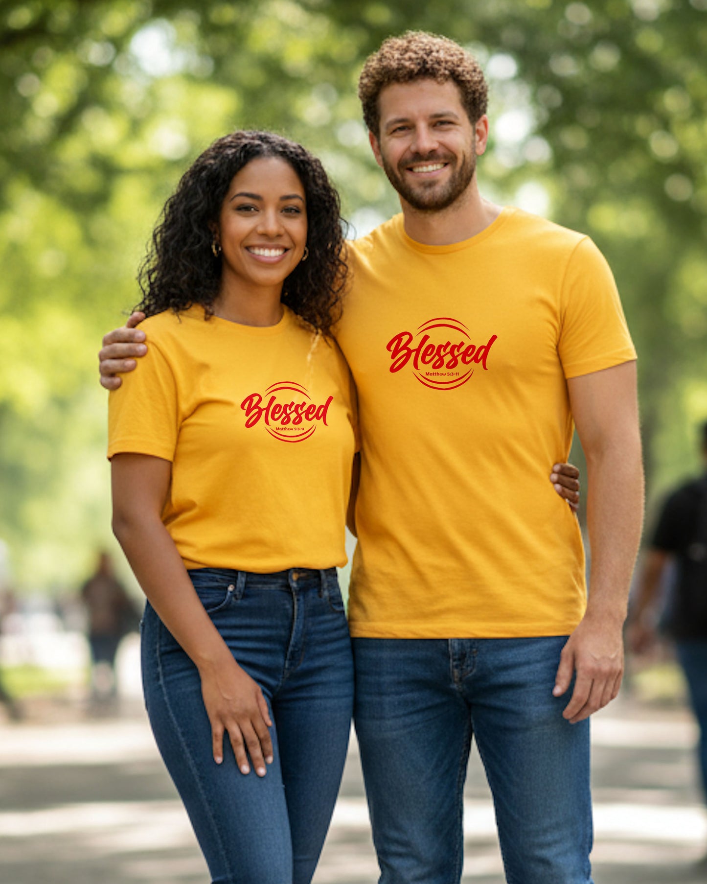 A woman and a man wearing yellow 'Blessed' t-shirts standing in a park.