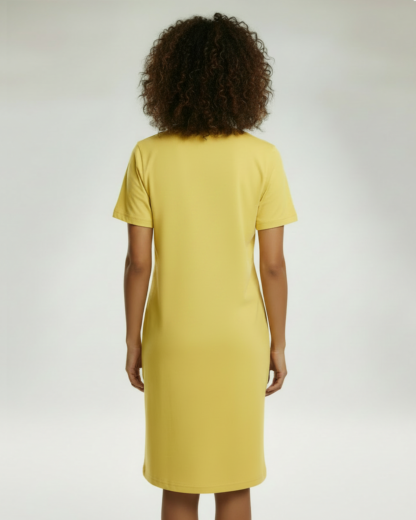 Rear view of woman wearing a yellow t-shirt dress.