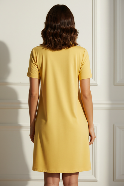 Rear view of a woman wearing a yellow t-shirt dress in a white wall panel room