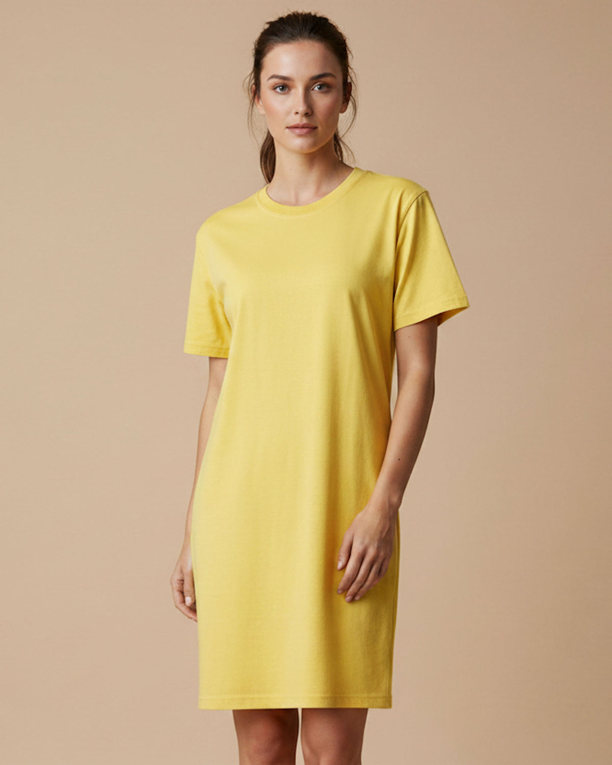 A woman modeling a plain short-sleeve yellow dress against a solid beige studio background.