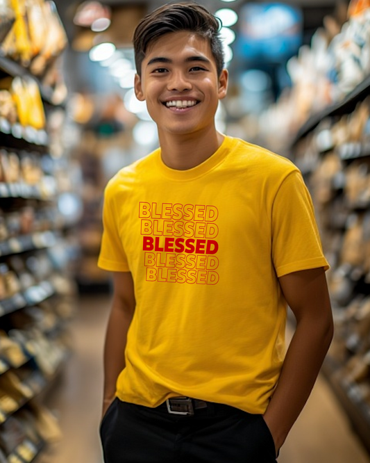 A young man in a shopping mall wearing a yellow t-shirt with multiple lines of "Blessed" text printed on the front.