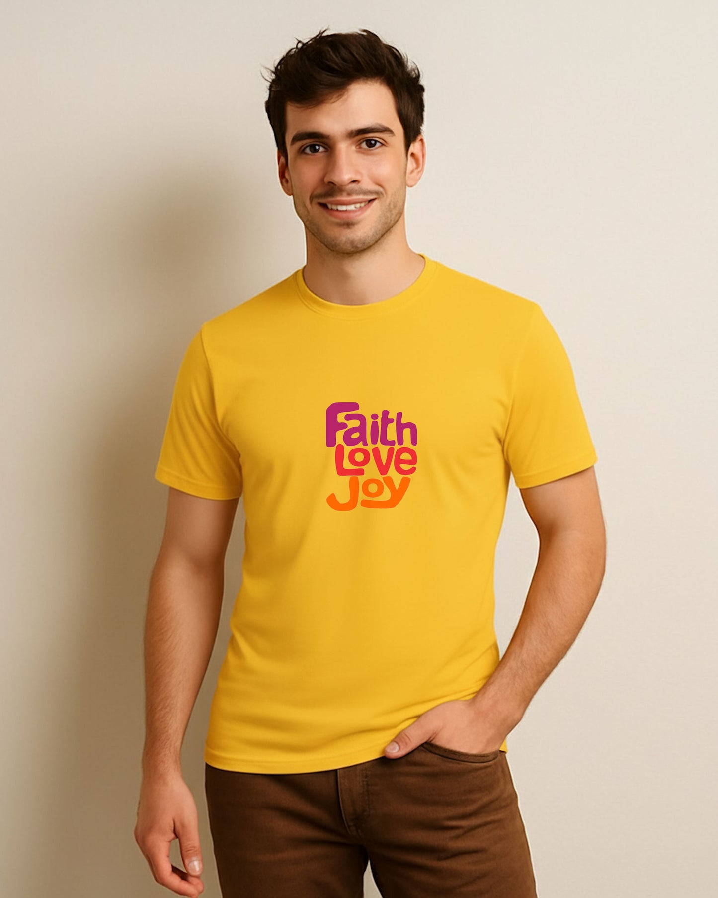 Man wearing a yellow t-shirt with 'Faith Love Joy' text against a beige background